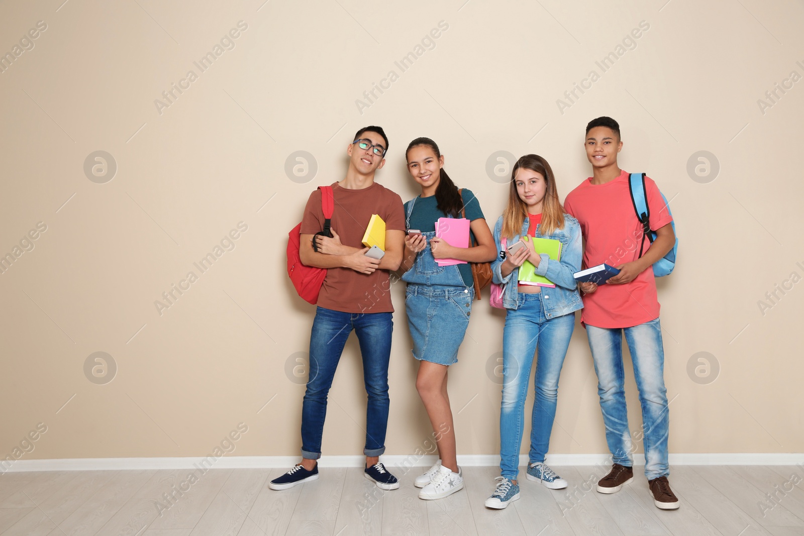 Photo of Group of teenagers against color wall, space for text. Youth lifestyle and friendship