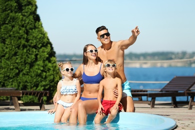 Photo of Happy family at poolside on sunny summer day