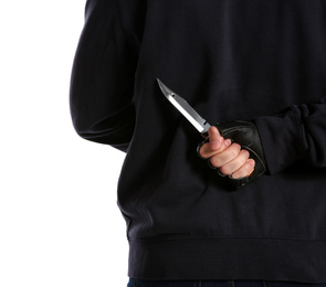 Photo of Man with knife behind his back on white background, closeup. Dangerous criminal