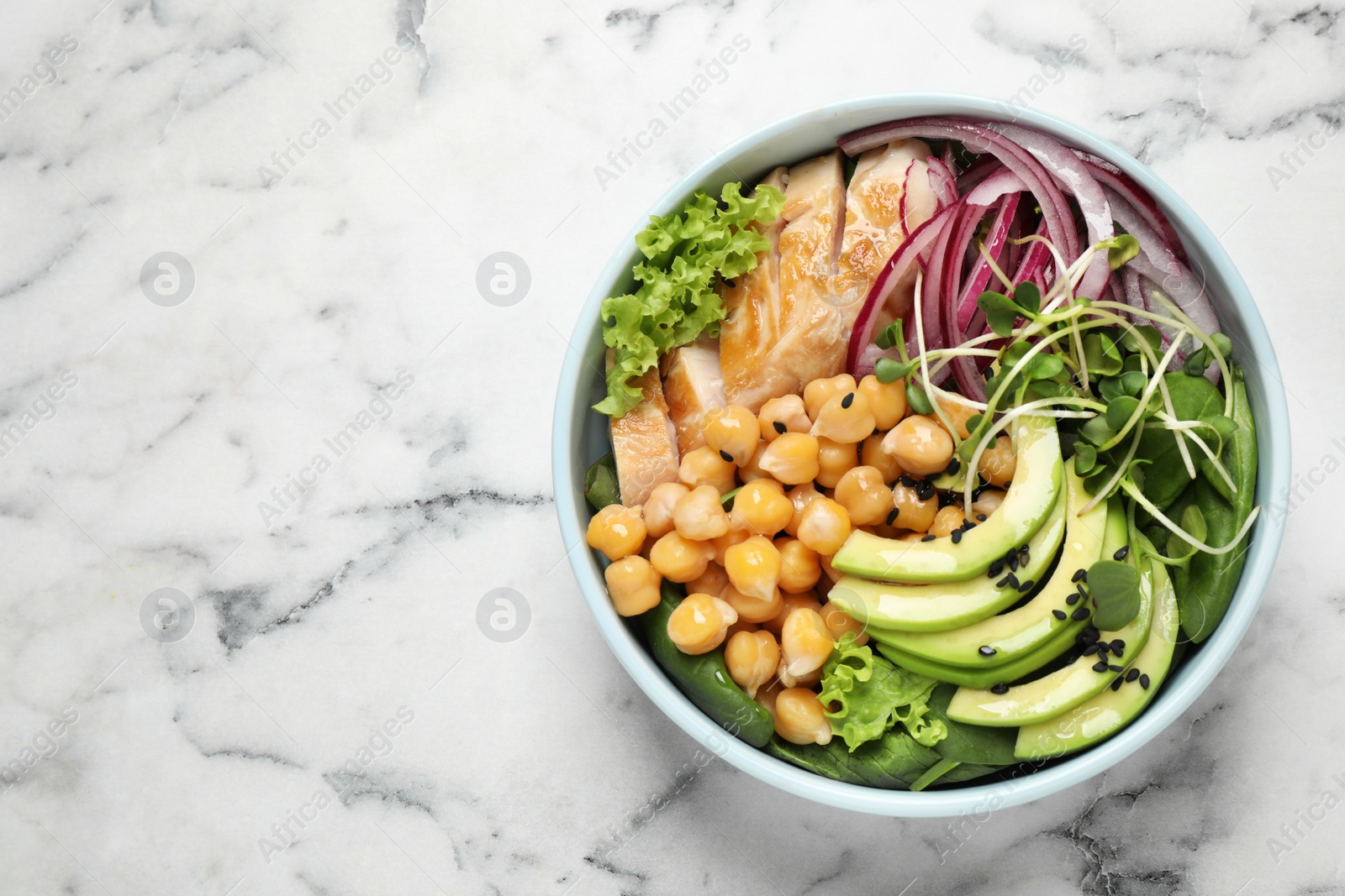 Photo of Delicious avocado salad with chickpea on white marble table, top view. Space for text