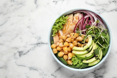 Delicious avocado salad with chickpea on white marble table, top view. Space for text