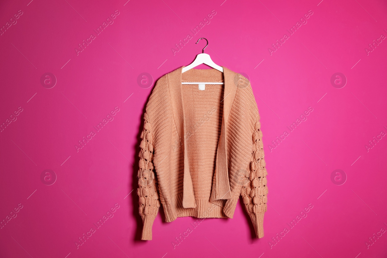 Photo of Hanger with stylish sweater on color background