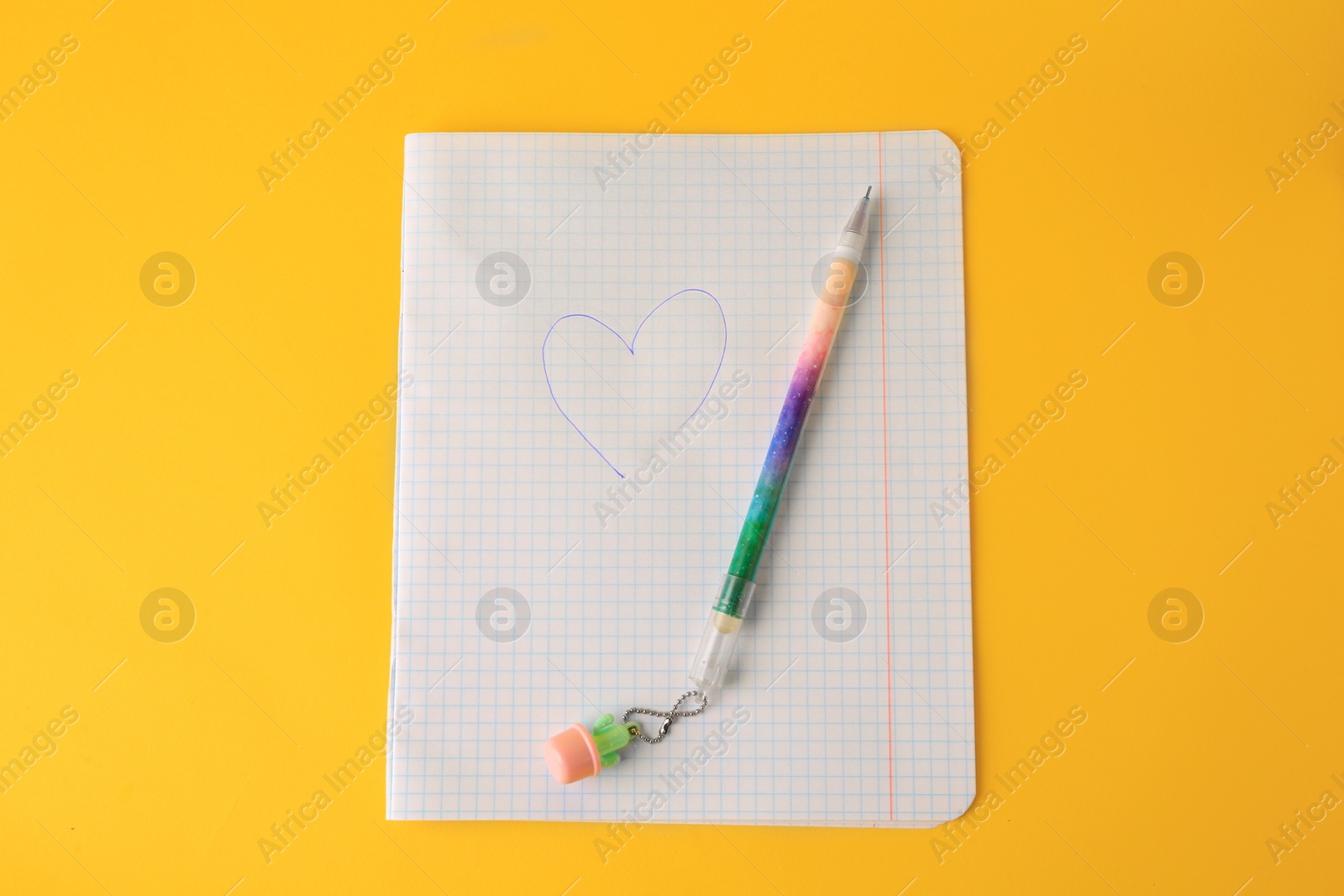 Photo of Heart drawn on checkered paper with erasable pen against yellow background, top view