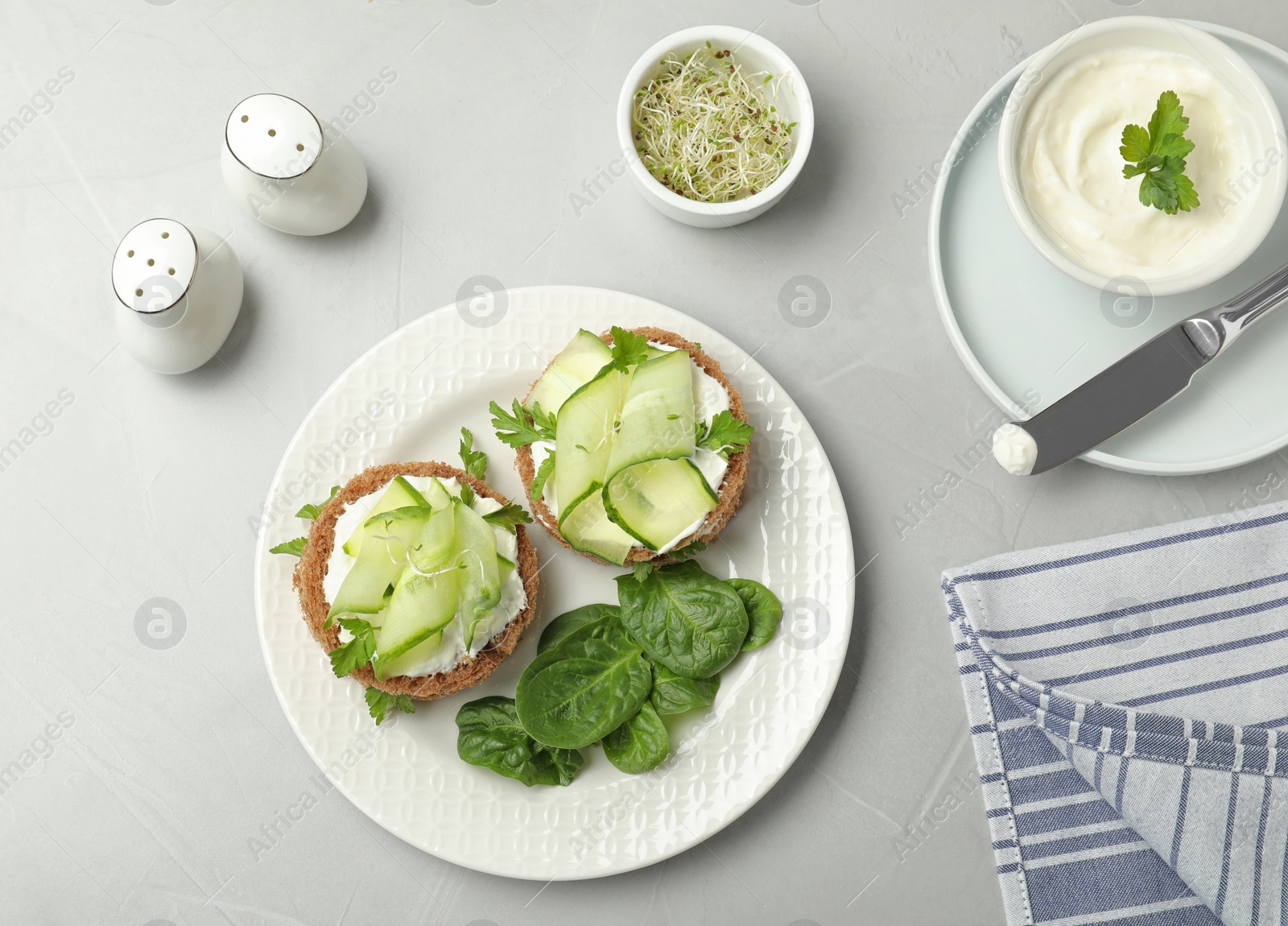 Photo of Flat lay composition with traditional English cucumber sandwiches on grey background