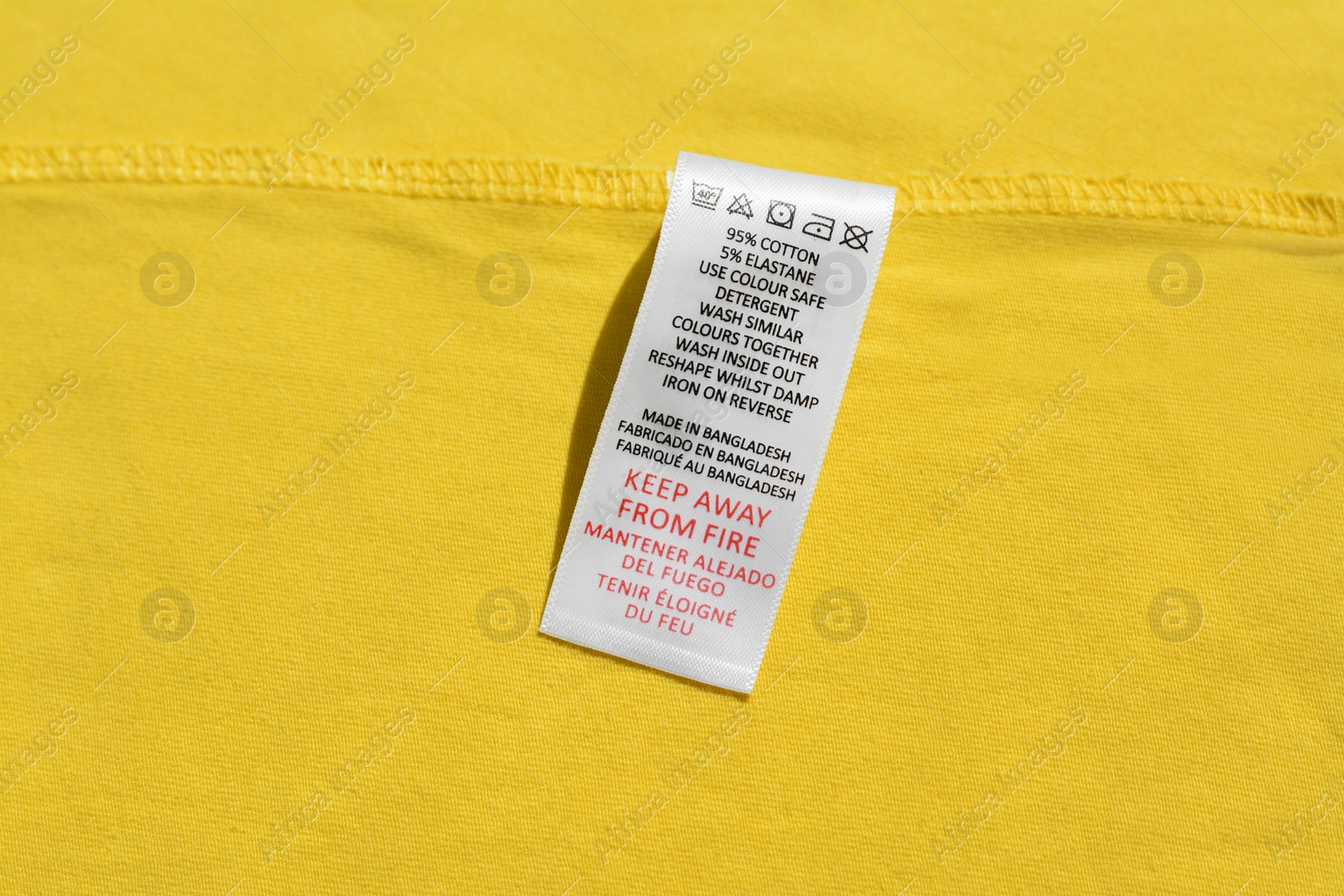 Photo of Clothing label on yellow garment, top view