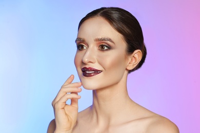 Photo of Beautiful young woman with glitter makeup on colorful background