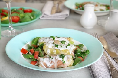 Photo of Plate with stuffed cabbage leaves and sour cream on table