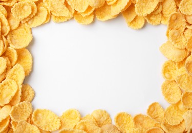 Photo of Frame made of tasty corn flakes on white background, top view. Space for text