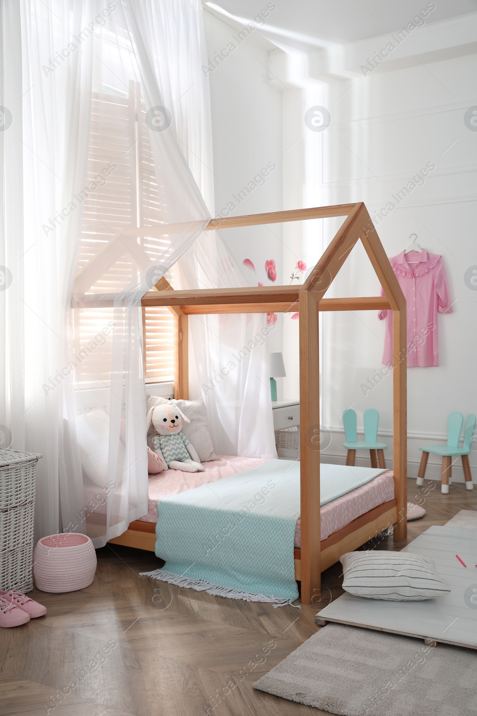 Photo of Stylish child room interior with wooden house bed