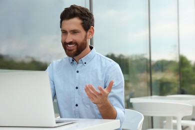 Handsome man with laptop in outdoor cafe