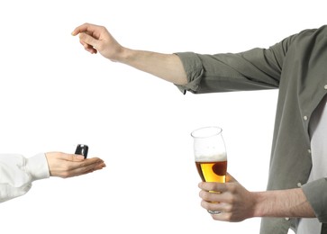 Photo of Man with glass of alcoholic drink giving car key to woman on white background, closeup. Don't drink and drive concept