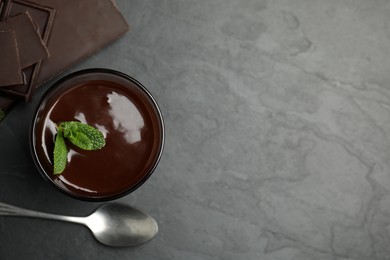 Glass of delicious hot chocolate with mint on dark grey table, flat lay. Space for text