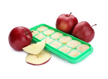 Photo of Apple puree in ice cube tray and ingredients on white background. Ready for freezing