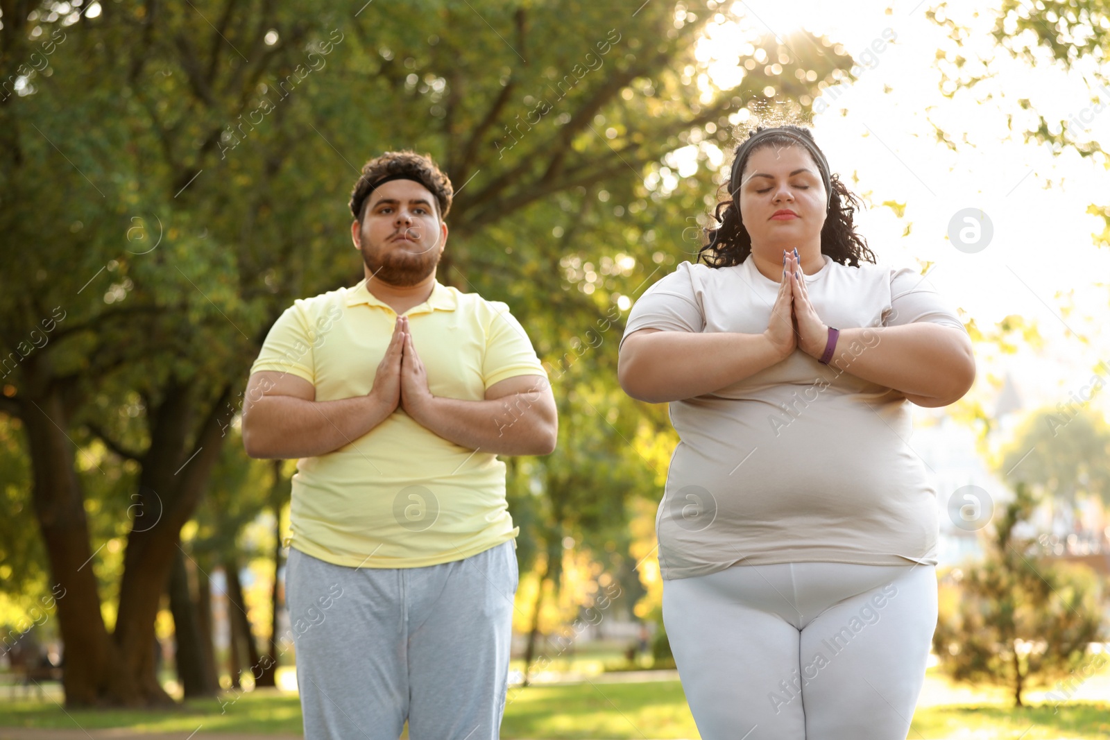 Photo of Overweight couple training together in park on sunny day