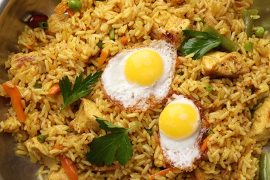 Tasty rice with meat, eggs and vegetables in frying pan, top view