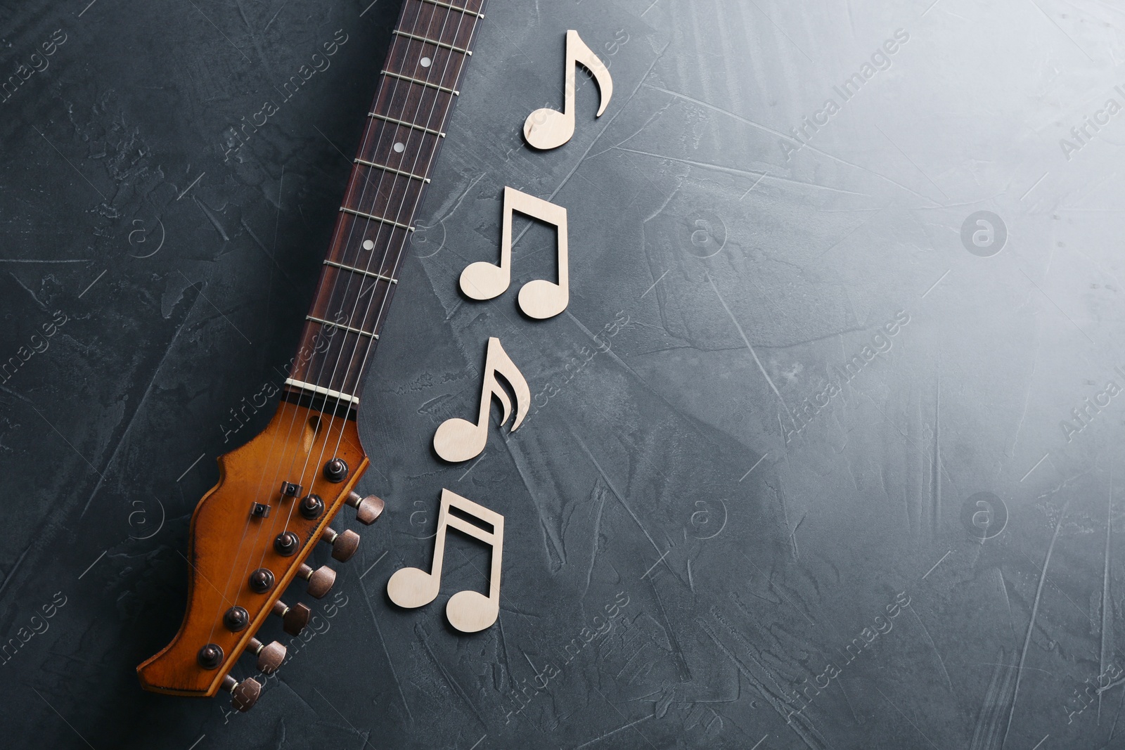 Photo of Guitar neck and music notes on grey background, flat lay. Space for text