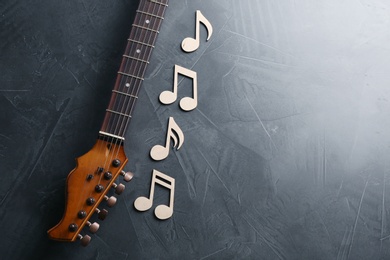 Guitar neck and music notes on grey background, flat lay. Space for text