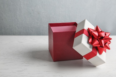 Photo of Beautiful gift box on white wooden table. Space for text