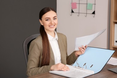Businesswoman working with documents at wooden table in office