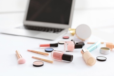 Photo of Makeup products for woman and laptop on table