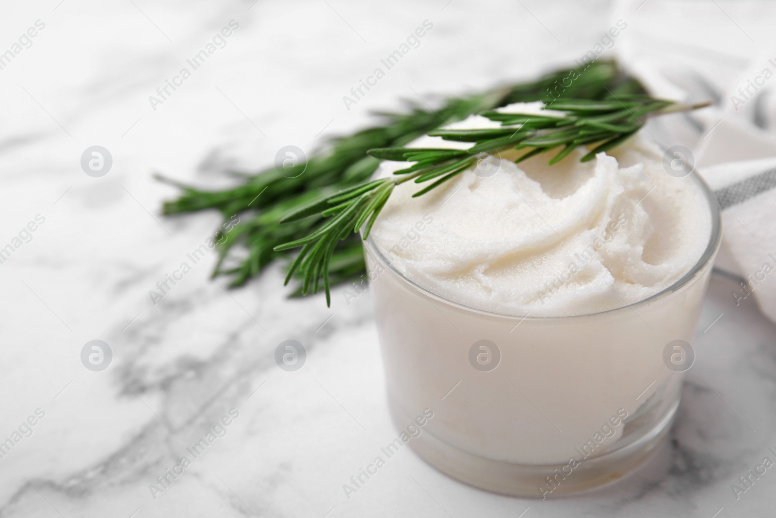 Photo of Delicious pork lard with rosemary in glass on white marble table, closeup