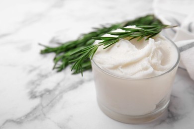 Delicious pork lard with rosemary in glass on white marble table, closeup