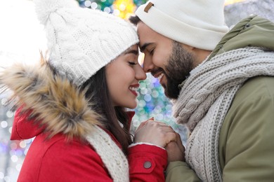 Photo of Happy young couple spending time together at winter fair. Christmas celebration
