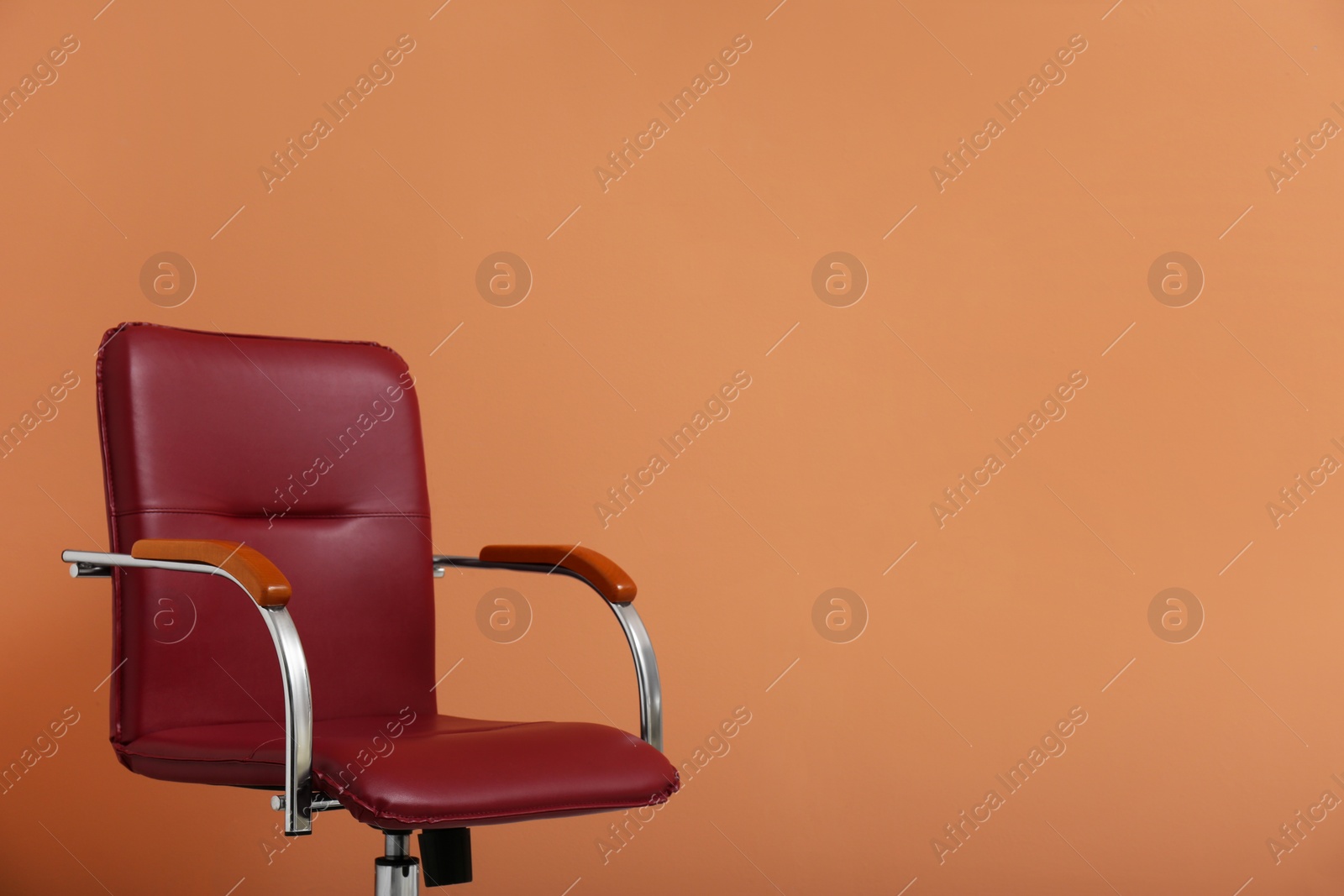 Photo of Modern office chair on orange coral background. Space for text