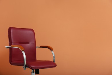 Modern office chair on orange coral background. Space for text