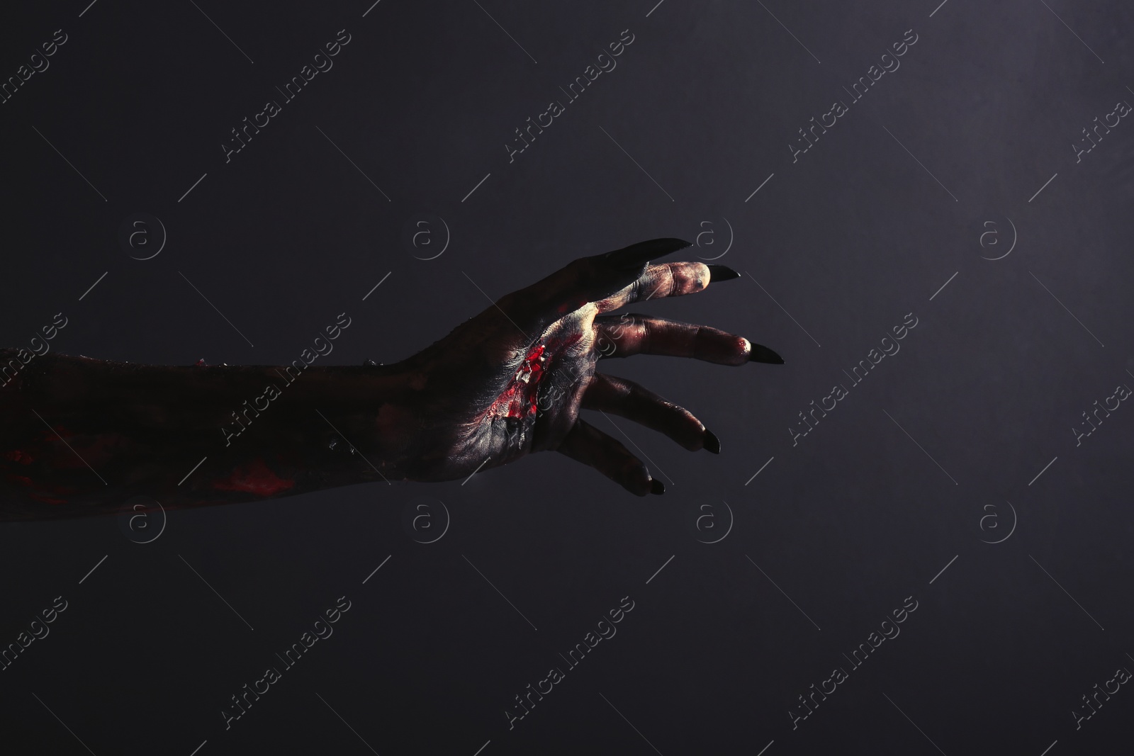 Photo of Scary monster on black background, closeup of hand. Halloween character