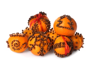 Photo of Pile of pomander balls made of fresh tangerines with cloves on white background