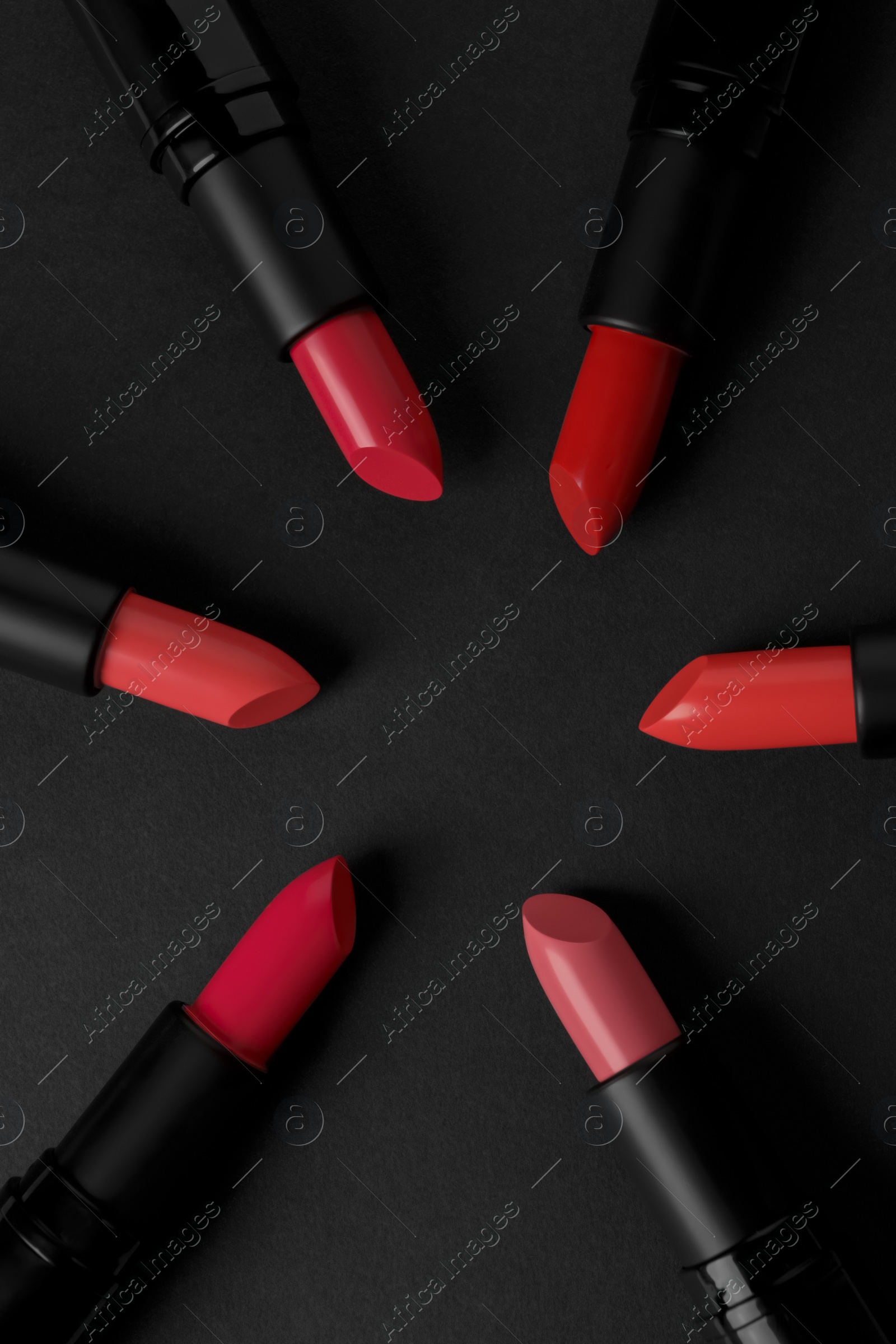 Photo of Beautiful lipsticks on black background, flat lay