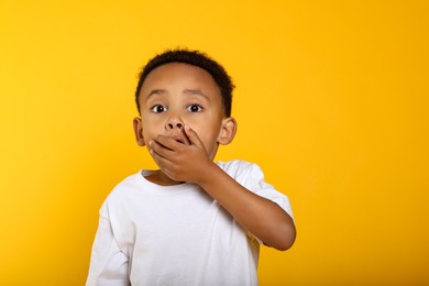 Photo of Portrait of emotional African-American boy on yellow background