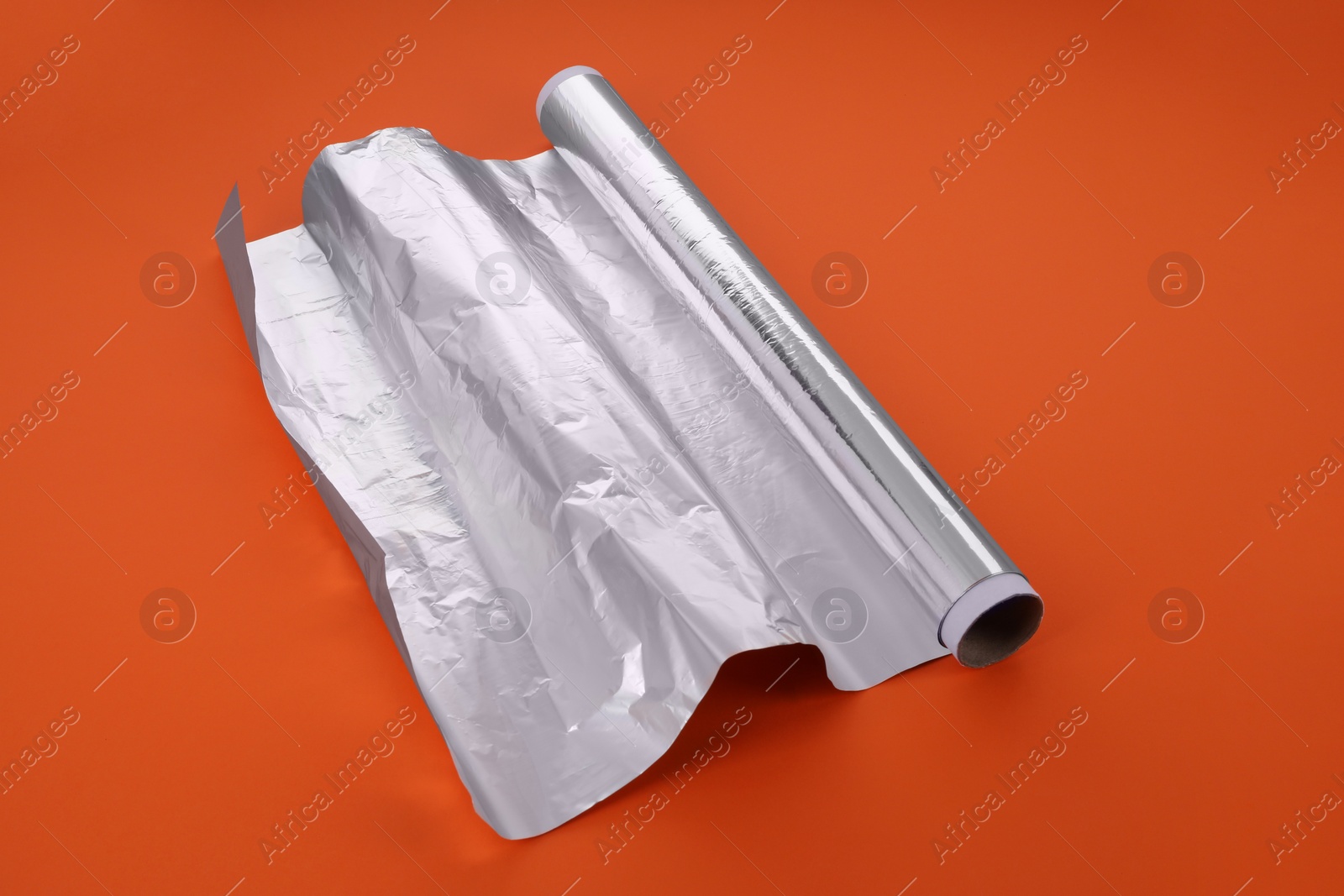 Photo of Roll of aluminum foil on orange background