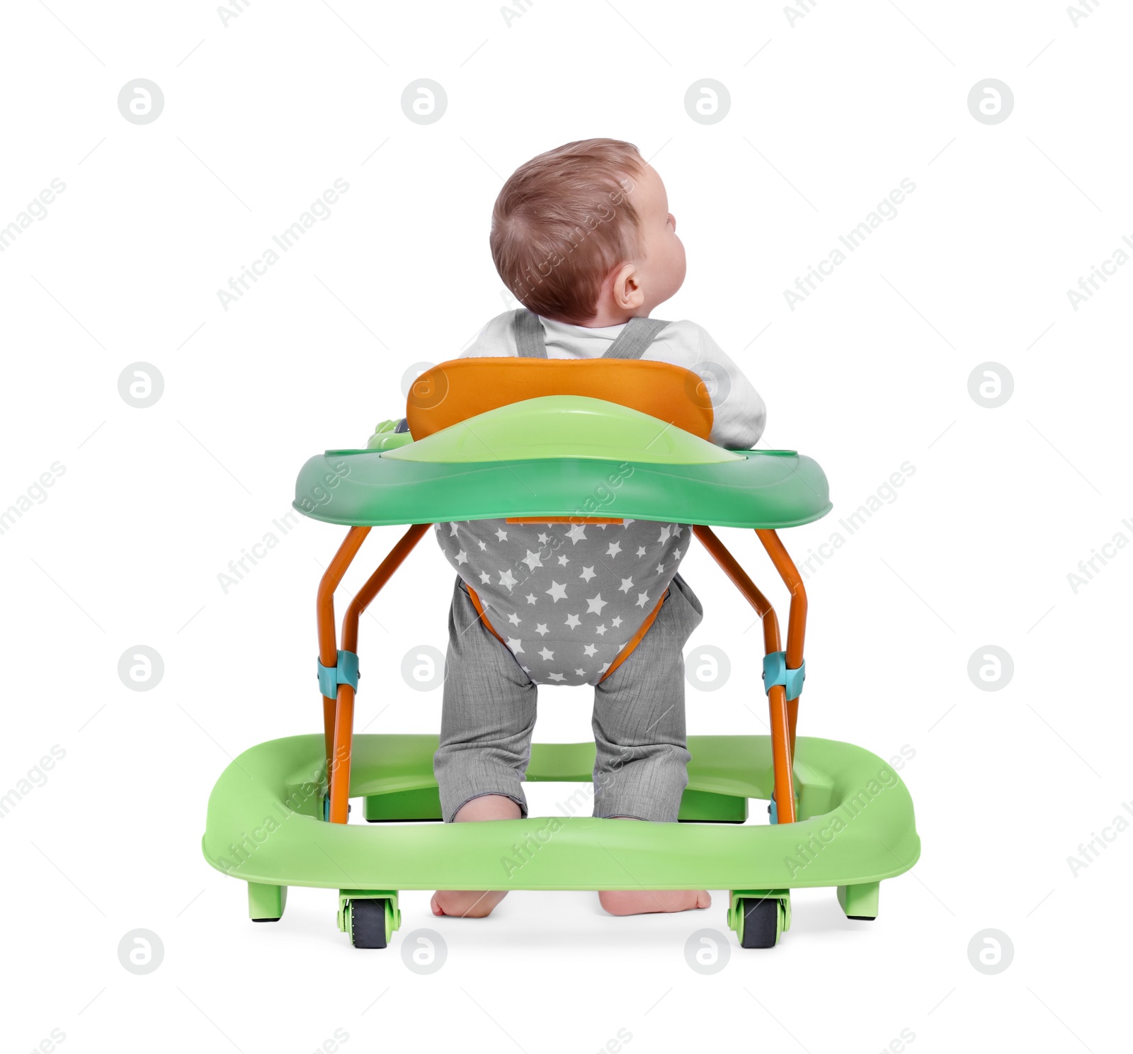 Photo of Cute little boy making first steps with baby walker on white background, back view