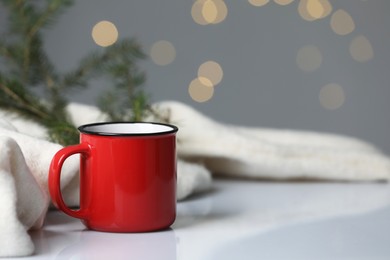 Cup of drink on white table against blurred festive lights, space for text