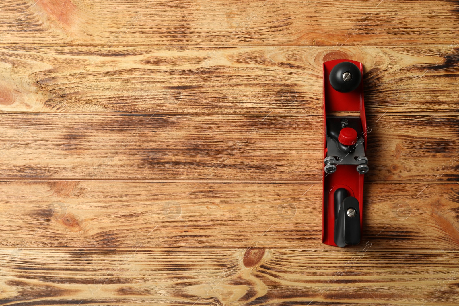 Photo of Modern jack plane and space for text on wooden background, top view. Carpenter's tool