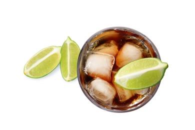 Glass of cocktail with cola, ice and cut lime on white background, top view