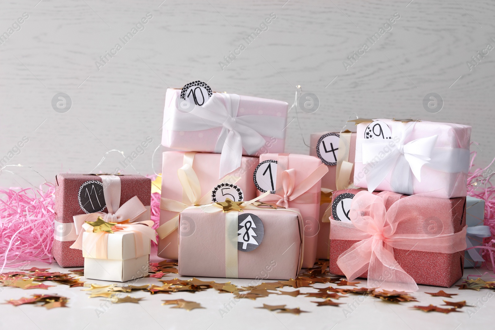 Photo of Gifts for Christmas advent calendar and confetti on white table