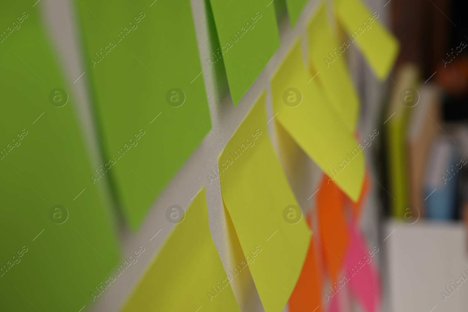 Photo of Blank colorful paper notes on white board, closeup