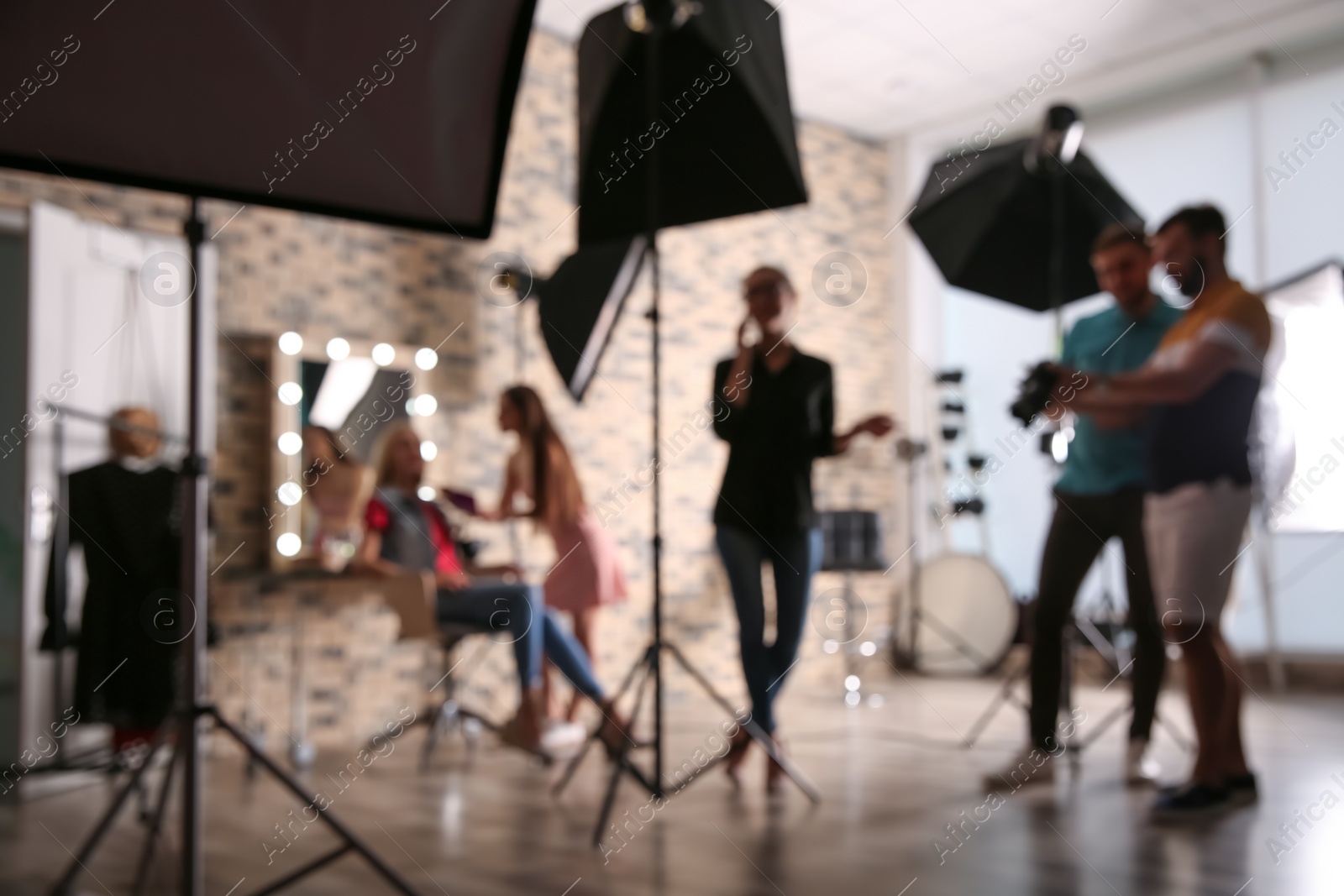 Photo of Blurred view of professional team working with model in photo studio