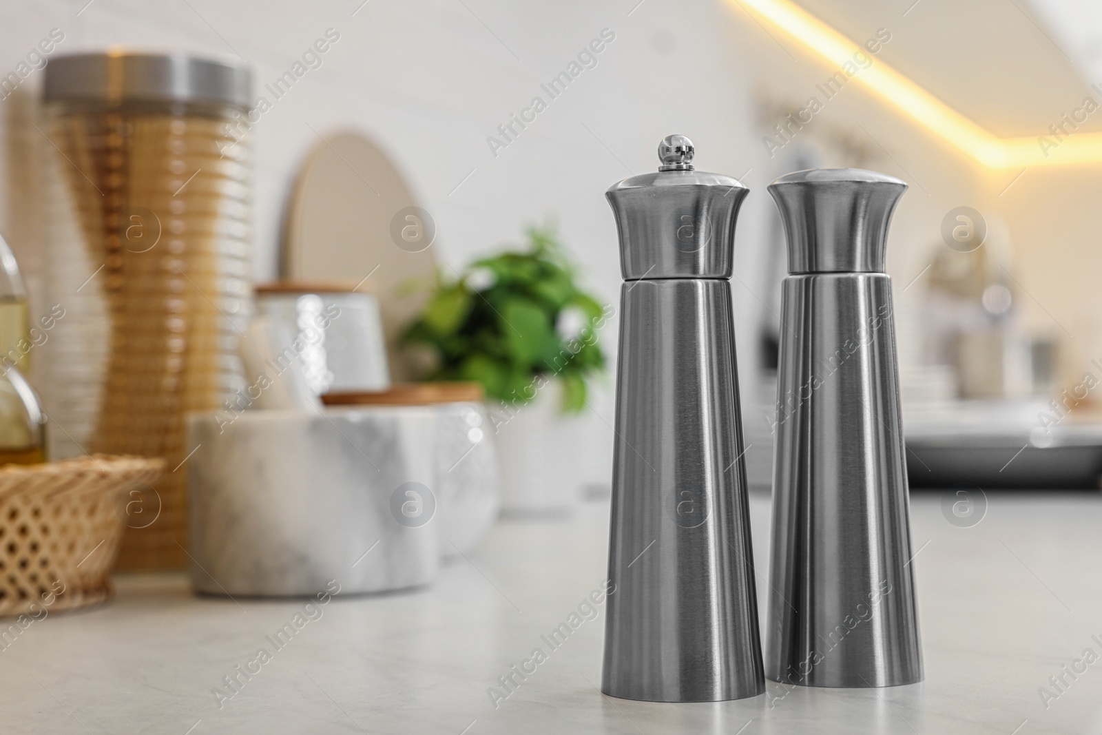 Photo of Stainless steel salt and pepper shakers on table, space for text