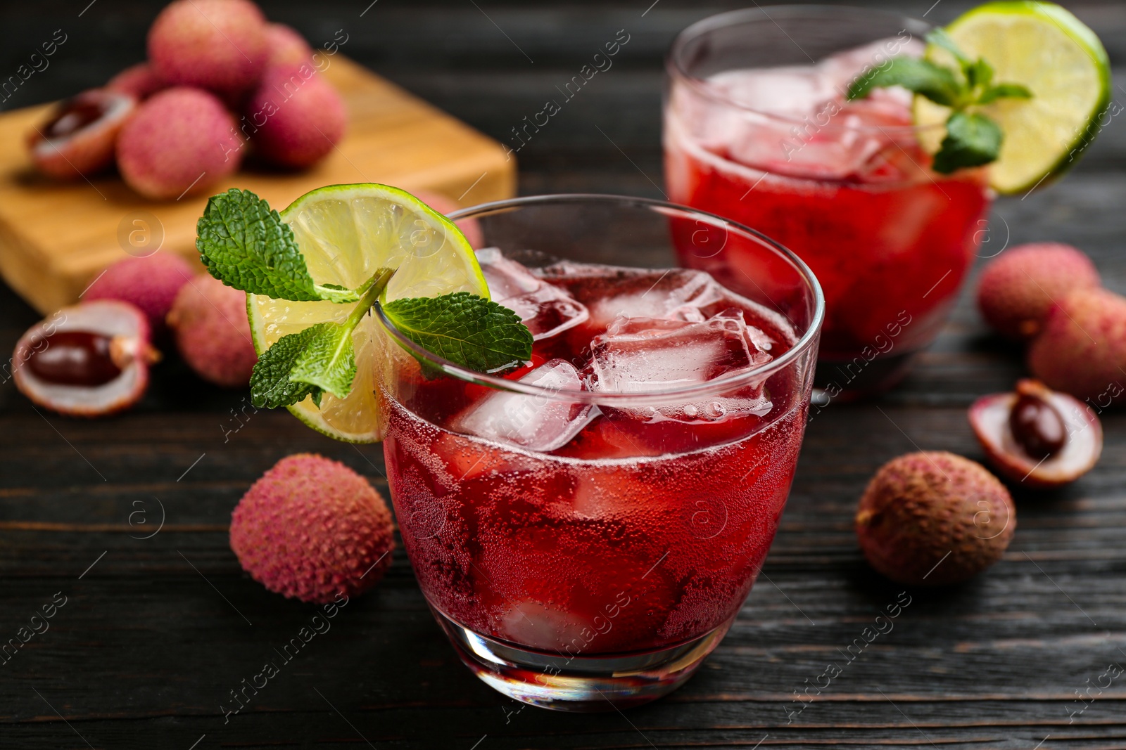 Photo of Lychee cocktail with lime, ice and mint on dark wooden table