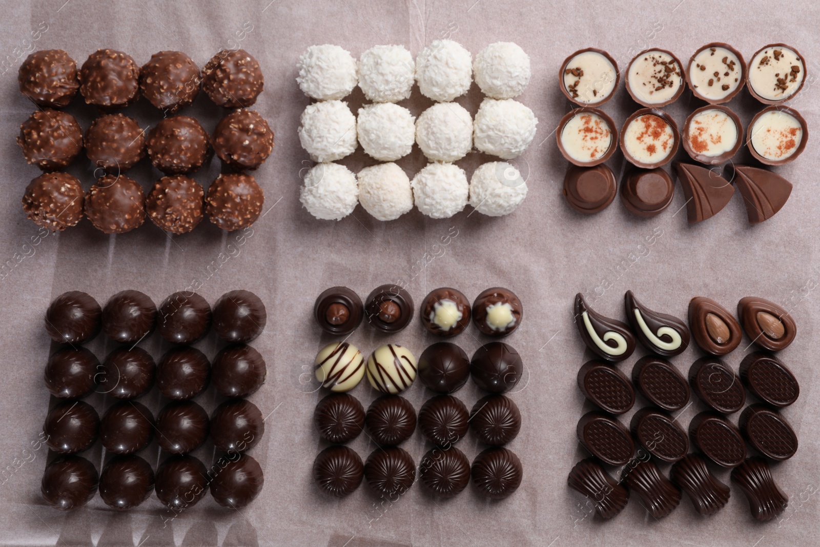 Photo of Many delicious chocolate candies on table, flat lay. Production line