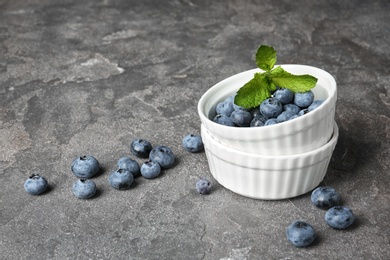 Photo of Crockery with juicy and fresh blueberries on table. Space for text
