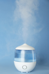 Photo of Modern air humidifier on light blue background