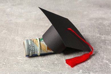Photo of Scholarship concept. Graduation cap and banknotes on light grey table