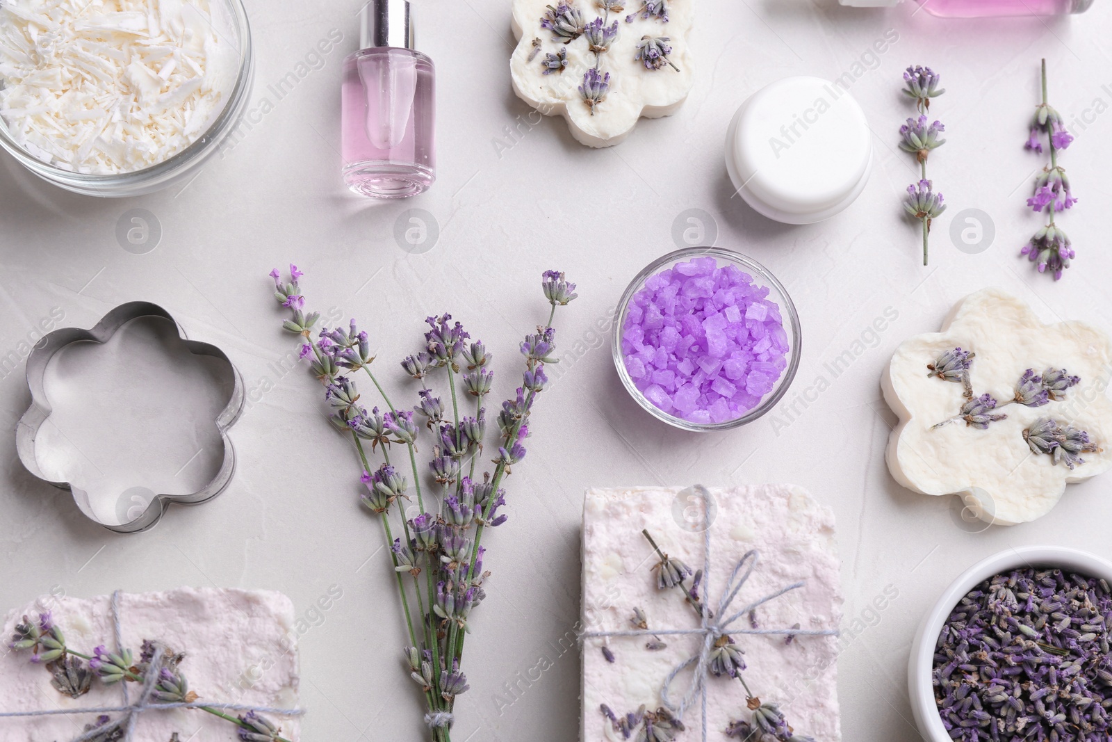 Photo of Flat lay composition with hand made soap bars and lavender flowers on light stone surface