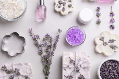 Flat lay composition with hand made soap bars and lavender flowers on light stone surface