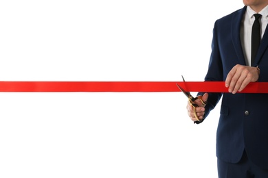 Man in office suit cutting red ribbon isolated on white, closeup